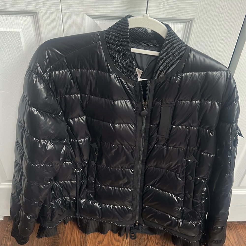 Black, shiny Puffer jacket Pull string around the  velour lining on the zip